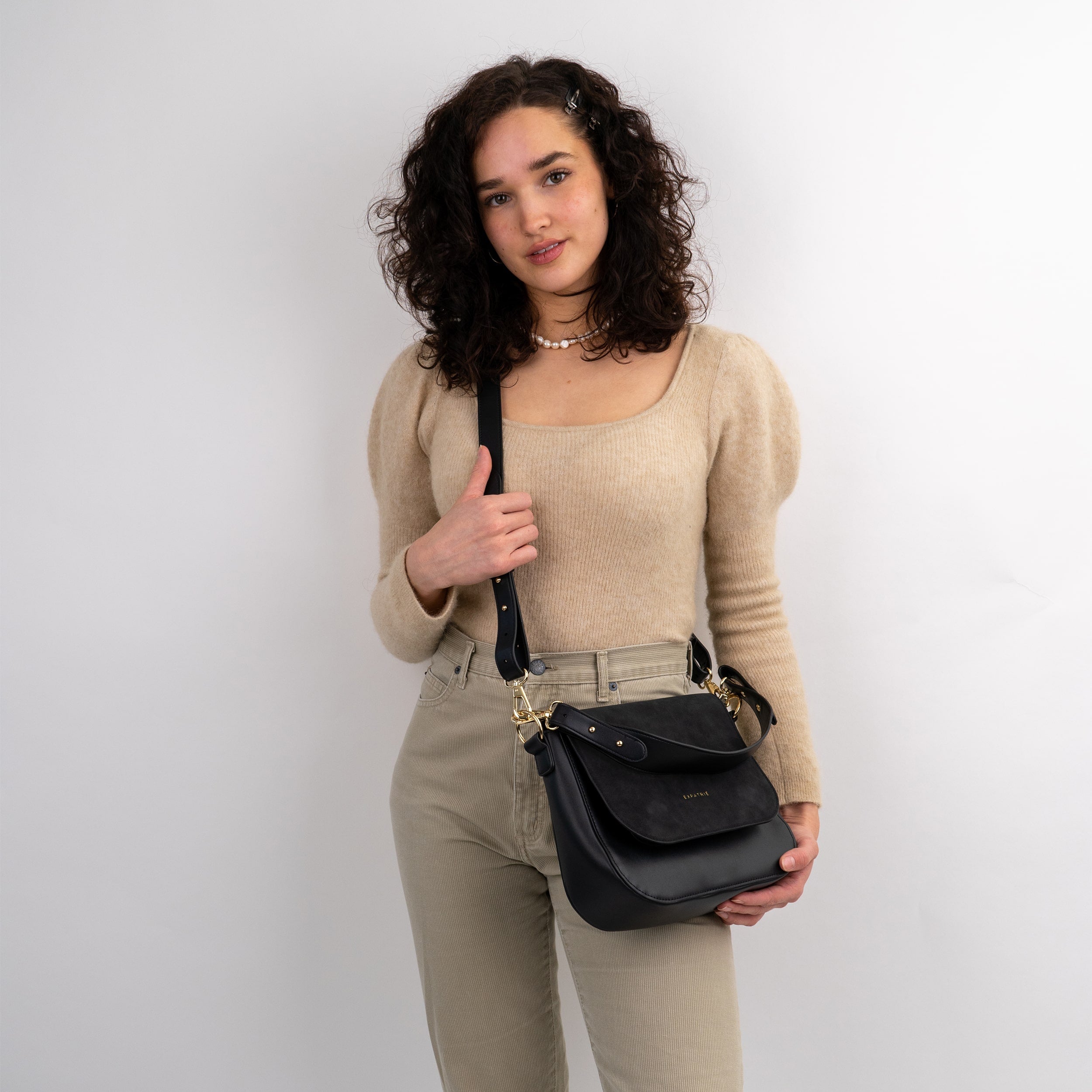 Frau trägt schwarze Saddle Bag Louise Large aus Leder mit verstellbarem Riemen